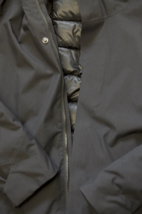 En sort jakke der er lynet op. Jakken er isoleret med dunfor.