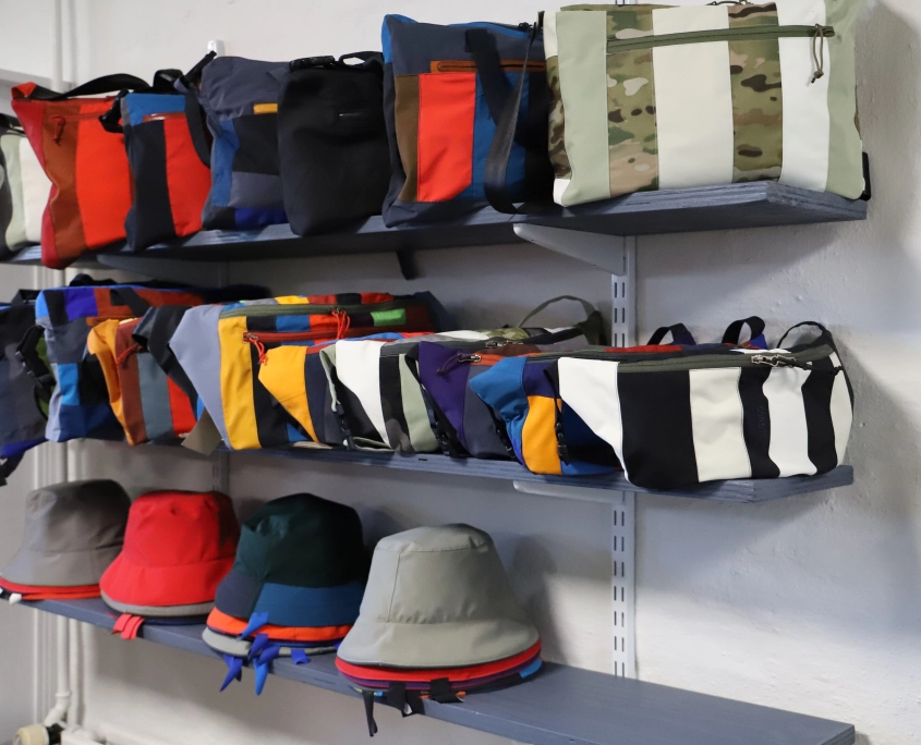 Tasker og hatte vi har lavet ud af aflagte jakker opstillet på tre hylder. De har forskellige farver, størrelser og mønstre.